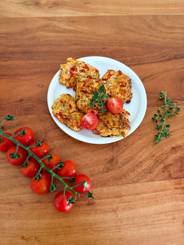 Proteinreiche Hüttenkäsetaler mit Cherrytomaten dekorativ angerichtet auf Holztisch