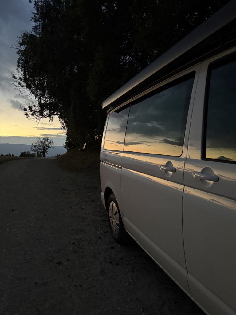 VW Envia Camper Freely auf einem Feldweg in der Abendsonne