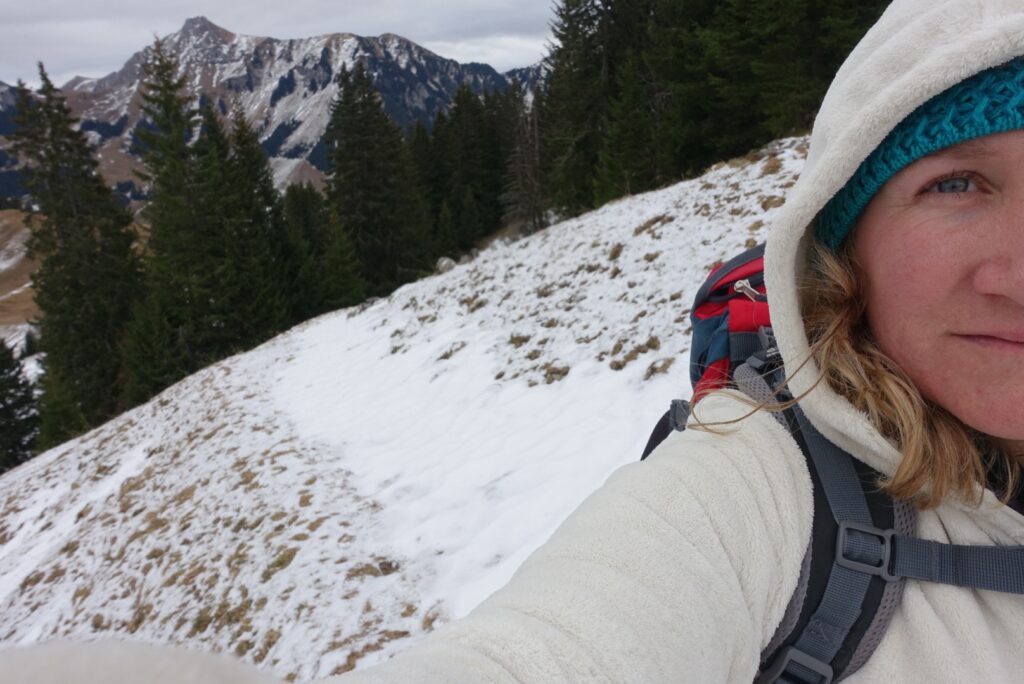 Frau beim Wandern im Winter in den verschneiten Schweizer Bergen