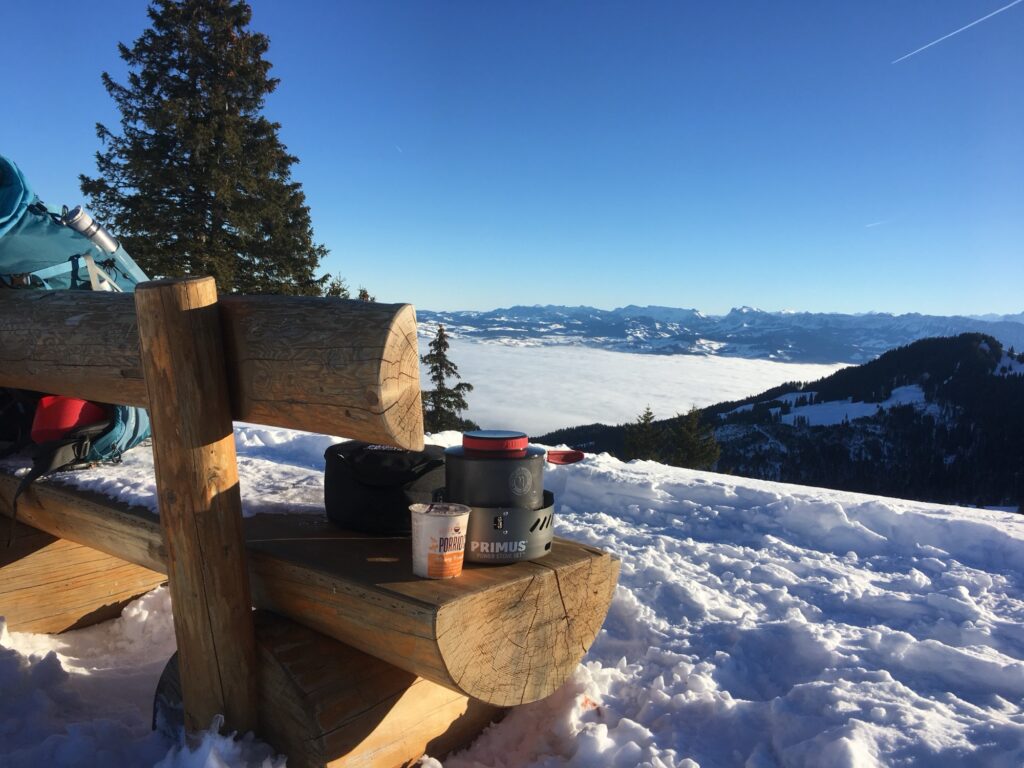 Winterwanderung mit Trekkingausrüstung und Blick über das Nebelmeer in den Schweizer Bergen